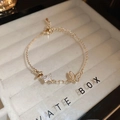 Dettaglio del bracciale farfalla in oro con zirconi e intarsio in conchiglia bianca - Bracciale-Oro (Placcato Oro 14K)