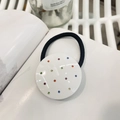 Dettaglio di un elastico Y2K con strass colorati a forma di cuore su un libro - Bianco-Tondo Diamante Colorato-Elastico