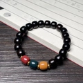 Dunkelbraunes Ebenholz-Armband mit bunten Perlen auf einem Kalligraphie-Buch - Afrikanisches Grenadill Dreifarbige Perlen im Alten Stil