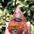 Hand holding a resin energy pyramid with pink crystal stones and moon pattern - Pink Ball Butterfly / Small