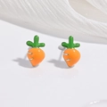 Vue détaillée des boucles d'oreilles carottes avec émail orange et vert sur fond de tissu - Carotte Orange
