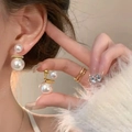 Elegant bow earrings featuring double white pearls and golden metallic finish detail - Gold Double Pearl Studs
