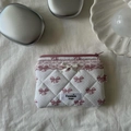 Detailed top view of quilted cotton cosmetic bag with pink bow pattern on beige fabric - Bow Lipstick Bag / Purple
