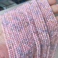Faceted small pink and purple semi-precious natural stone beads held in hand for jewelry making - Morganite 3mm