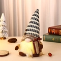Close-up of a lit coffee gnome plush with LED light and striped hat in a cozy setting - Gift Bag Style