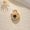 Macro shot of gold heart pendant with center stone and encircling small zircon stones - Heart Lock