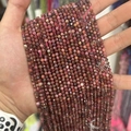 Faceted natural pink tourmaline beads for DIY jewelry making held in hand - Black Line Rhodochrosite 3mm