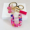 Detailed macro view of U-shaped letter keychain with pink resin, butterfly and tassel - Rose Red Butterfly Tassel Clip / Letter U