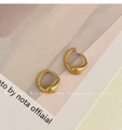 Matte gold drop-shaped hoop earrings with a brushed metallic finish on a magazine background - Matte Brushed Teardrop Clip / Gold