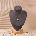 Elegant gold necklace with white clover pendant displayed on a wooden bust stand - Medium / Gray