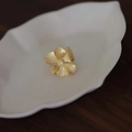 Golden flower ring with brushed texture petals and sparkling gems on a white dish - Gold Matte Texture Flower Ring (J4060)