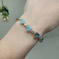 Detail of gold heart chain bracelet with sky blue enamel and sparkling zircon stones - Sky Blue