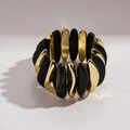 Detail eines klobigen elastischen Armbands mit mattschwarzen und goldenen Perlen - Schwarz