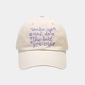 Detail of cream baseball cap with purple cursive embroidery and floral accents - Adjustable / Beige