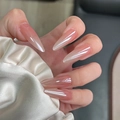 Close-up of pink gradient almond nails with crystal gems on soft silk fabric - By1594 Pink Aurora / Glue Type
