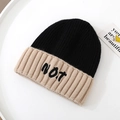 Dettaglio della trama a maglia e ricamo NOT sul berretto invernale bicolore - Solo Cappello / Nero