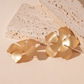 Macro detail van gouden matte bloemoorbellen met een geborstelde metalen textuur - Goud