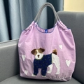 Detail view of pink nylon tote bag with cute 3D puppy embroidery and woven handles - Purple Pug