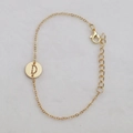 Golden delicate chain bracelet featuring a hollowed round pendant with letter D engraving - Gold D