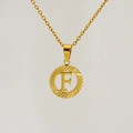 Detailed view of an 18K gold-plated hollow round pendant with letter F on a thin chain - Letter F