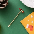 Détail d'une barrette sapin de Noël dorée ornée de strass rouges scintillants - Noël arbre