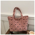 Pink corduroy tote bag featuring black bow patterns and quilted rhombus texture - Pink
