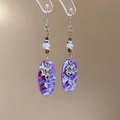 Detail of vintage earrings with purple marble resin pendant and silver flower decor - Purple Oval Pendant Style