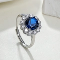 Detailopname van een zilveren halo-ring met een blauwe middensteen en fonkelende accenten - Blauw Glaskristal - Zilver