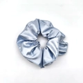 Detailed close-up of a blue satin scrunchie showing glossy texture and fabric folds - Blue