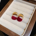 Gros plan d'élégantes boucles d'oreilles pétales en velours rouge dans un écrin - Boucles d'oreilles clous demi-cercle floquées or rouge (16#)