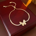 Detail of zircon butterfly bracelet in gold finish on a vintage wooden jewelry box - Gold