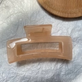 Macro shot of large pink rectangular hair claw clip with golden metal spring detail - Jelly Light Orange