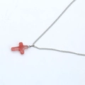 Cross necklace with red translucent stone pendant and silver chain on white background - Light Red