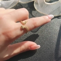 Anello a serpente dorato con pietre di zircone scintillanti su sfondo scuro - Anello Aperto a Forma di Serpente