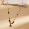 Detail of golden sweater chain with brown tiger eye beads and textured flower pendant - Necklace-Coffee Brown Flower