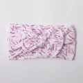 Close-up of soft nylon baby headband featuring a pink baseball stitch printed bow - Pink Baseball Stitches Pattern