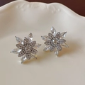 Detail of vintage-style flower stud earrings with sparkling crystals on a ceramic tray - 925 Sterling Silver Earring Post - 3D Snowflake Flower Rhinestone Studs
