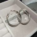 Detail of silver multi-layer intertwined hoop earrings on a beige velvet jewelry pad - Silver (Silver Pin)