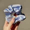 Close-up of light blue silk scrunchie showing glossy satin texture and elegant pleats - Aqua