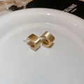 Detailed macro view of gold matte geometric C-shaped stud earrings in a ceramic dish - Golden Matte C-shape Square Style (HE12856)