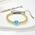 Detailed shot of an adjustable evil eye bracelet with golden beads and blue heart charm - Pale Blue Heart