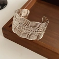 Dettaglio del motivo in pizzo argentato sull'ampio bracciale aperto in metallo - Bracciale Rigido Aperto Largo Cavo / Argento