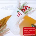 White knitted Christmas stocking with red embroidered letter W and green holly leaf accents - Letter W / White