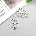 Close-up of two hollow antique silver clover pendants for DIY jewelry making - Hollow Four-leaf Clover 17x12mm