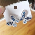 Detail of silver butterfly earrings featuring blue rectangular stones and white zircons - White Gold Blue Zirconia