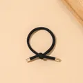 Close-up of black elastic hair tie with minimalist knot and gold metal cylinder ends - Ribbed Knot - Metal Buckle / Black