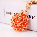 Detail shot of a double-sided daisy flower keychain with golden petals and orange accents - Orange
