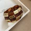 Primer plano de pulsera de eslabones en resina ámbar y metal dorado en su caja - Estilo 5 - Color Café Oscuro