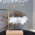Elegant long frosted white petal earrings with golden chains on a wooden display stand - E5417/Ear Clip Long White Matte
