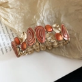 Dettaglio macro del bracciale elastico vintage in smalto arancione e trama a spirale - Stile Stretch con Motivo a Spirale Rosso Arancio / Rosso Arancio